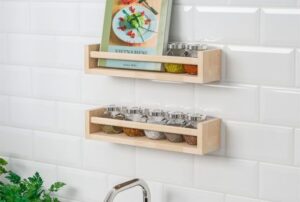  Wooden spice rack mounted on tiled kitchen wall holding jars and a cookbook

🖼️