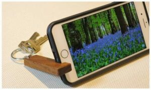 Minimalist keychain phone stand made of natural wood, perfect for hands-free phone use